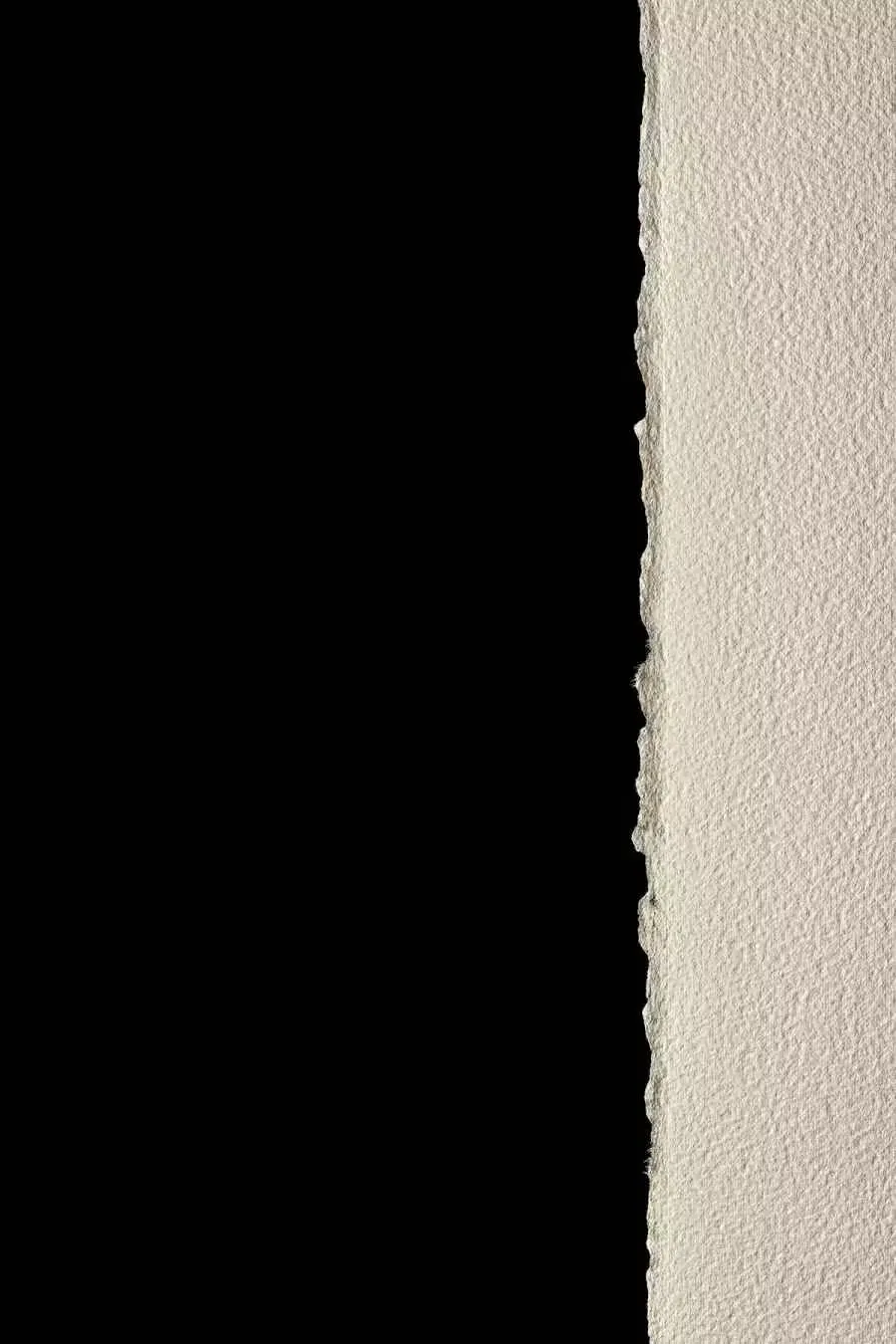 A sheet of rough paper on a black background