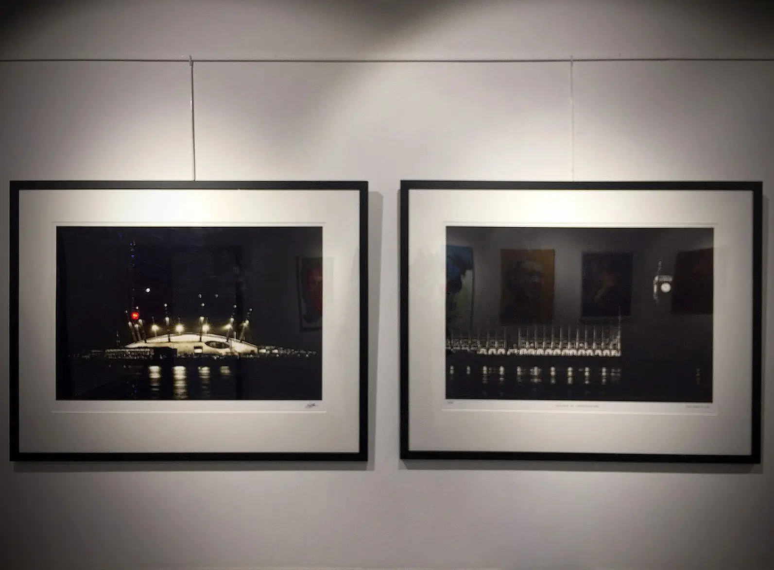 Two framed photos hanging in an art gallery